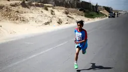 Seorang anak Palestina bersemangat berlari selama maraton lokal yang diselenggarakan oleh Culture and Free Thought association di Khan Younis di Jalur Gaza selatan (28/4/2016). (REUTERS / Ibraheem Abu Mustafa)