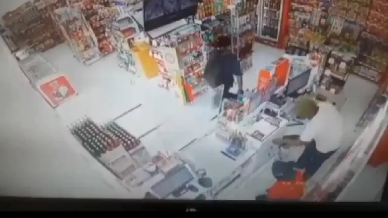 Tangkapan layar CCTV yang merekam aksi perampokan bersenjata api di minimarket