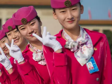 Para pemandu berpose  di lapangan Tiananmen selama sesi penutupan Kongres Partai Komunis ke-19 di Beijing (24/10). Sejumlah wanita cantik ini ditugaskan untuk memandu para peserta kongres. (AFP Photo/ Nicolas Asfouri)