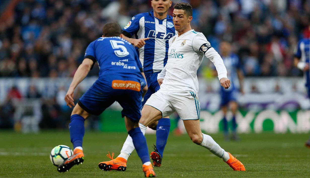Penyerang Real Madrid, Cristiano Ronaldo berusah mengumpan bola saat bertanding melawan Alaves pada pertandingan La Liga Spanyol di stadion Santiago Bernabeu (24/2). Ronaldo mencetak dua gol dipertandingan ini. (AP Photo/Francisco Seco)