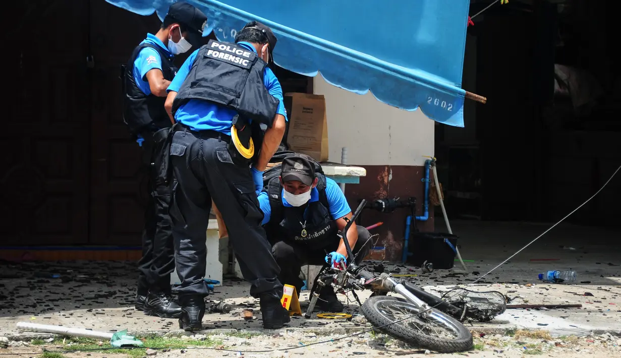 Polisi memeriksa lokasi ledakan bom motor di luar sebuah sekolah di distrik Tak Bai, Thailand, Selasa (6/9). Bom yang disembunyikan di tangki bahan bakar sepeda motor meledak saat para siswa dan guru memasuki halaman sekolah. (Madaree TOHLALA/AFP)