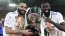 Pemain Real Madrid, Karim Benzema dan Antonio Rudiger mengangkat piala Copa del Rey 2022/2023 setelah berhasil mengalahkan Osasuna 2-1 dalam partai final di La Cartuja, Minggu (7/5/2023). (AP Photo/Jose Breton)