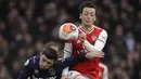 Pemain Arsenal, Mesut Ozil, duel udara dengan pemain West Ham United, Aaron Cresswell, pada laga Liga Inggris di Stadion Emirates, Sabtu, (7/3/2020). (AP Photo/Matt Dunham)