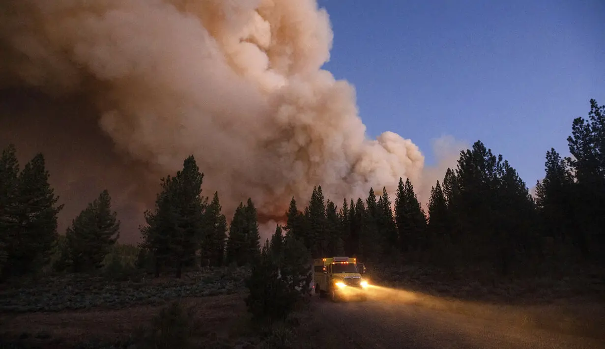 Gumpalan asap membubung di atas jalan raya saat kebakaran di Hutan Nasional Plumas, California (8/7/2021). Kebakaran kali ini merusak 91 bangunan. (AP Photo/Noah Berger)