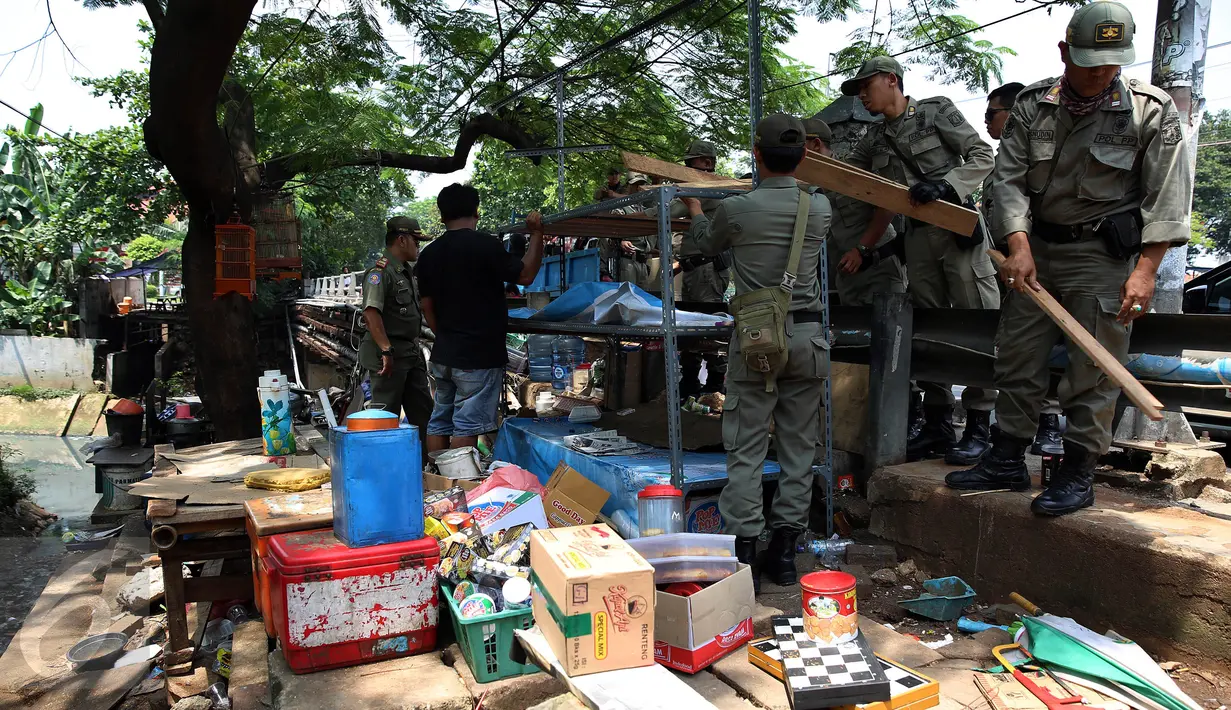 Petugas Satpol PP menertibkan lapak pedagang kaki lima (PKL) di pinggir jalan Kawasan Palmerah, Jakarta, Senin (17/10). Aktifitas ini dilakukan guna membuat jera  pedagang  yang nakal dan tetap nekat berjualan di Bahu jalan. (Liputan6.com/Johan Tallo)