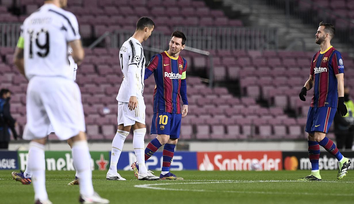 Striker Barcelona, Lionel Messi, berbincang dengan striker Juventus, Cristiano Ronaldo, pada laga Liga Champions di Stadion Camp Nou, Rabu (9/12/2020). Laga tersebut menjadi ajang reuni dua mega bintang yakni Messi dan Ronaldo. (AFP/Josep Lago)