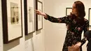 Kate Middleton melihat pameran fotografi di National Portrait Gallery Exhibition, London, 28 Februari 2018. Kate Middleton pun memadukan gaunnya dengan clucth bag senada dari brand Jimmy Choo. (AP/Frank Augstein)