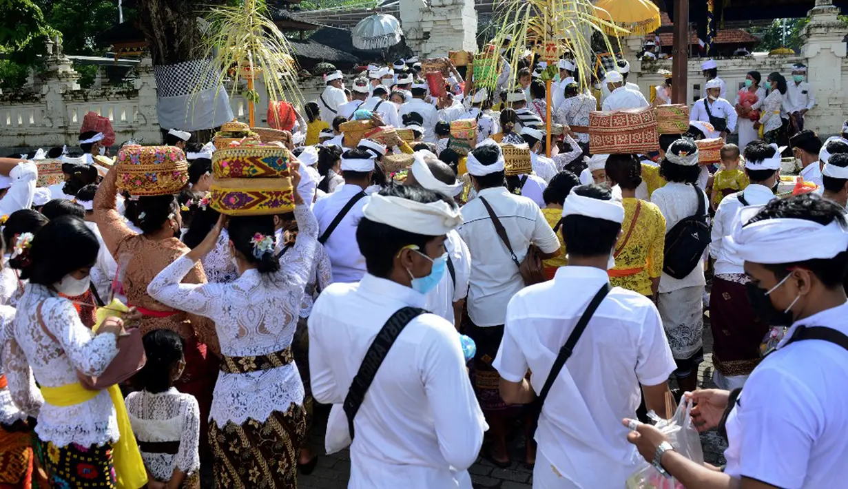 Umat Hindu membawa sesaji saat akan berdoa pada perayaan Hari Raya Kuningan di Pura Sakenan, Pulau Serangan, Denpasar, Bali, Sabtu (20/11/2021). Kuningan merupakan hari terakhir perayaan Galungan yang diyakini sebagai hari naiknya roh suci leluhur kembali ke surga. (Sonny TUMBELAKA/AFP)