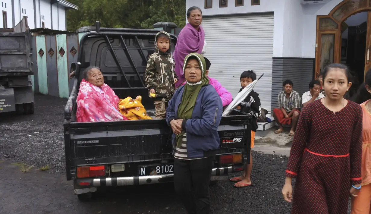 Wanita Indonesia duduk di belakang truk saat mereka bersiap untuk mengungsi dari rumah mereka setelah letusan Gunung Semeru di Lumajang, Jawa Timur, Indonesia, Selasa (1/12/2020). (AP Photo)
