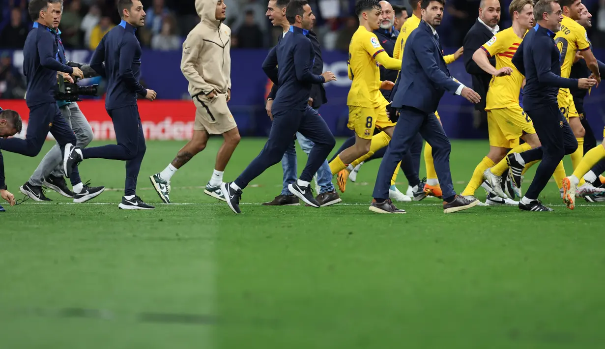 Selebrasi kemenangan yang dirayakan pemain Barca membuat penggemar tuan rumah ricuh memasuki lapangan. (Photo by Lluis GENE / AFP)