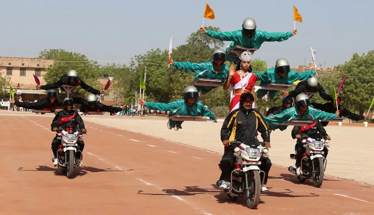 Para calon polisi India saat tampil beratraksi ekstrem di atas sepeda motor selama mengikuti parade di Pusat Pelatihan Polisi Rajasthan di Jodhpur, India, Jumat (24/4/2015).(AFP FOTO)