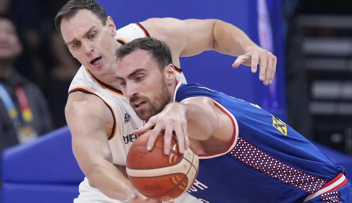 Pemain Timnas Basket Jerman, Johannes Voigtmann (kiri), berusaha merebut bola dari tangan pemain Serbia, Nikola Milutinov, dalam pertandingan final Piala Dunia FIBA 2023 yang berlangsung di Mall of Asia Arena, Pasay, Filipina, Minggu (10/9/2023) malam WIB. Johannes Voigtmann tercatat menyumbangkan delapan rebounds untuk Timnas Basket Jerman. Hasil itu, membuat Timnas Basket Jerman mencetak sejarah. (AP Photo/Michael Conroy)