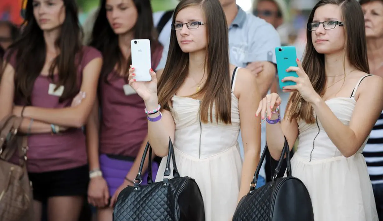 Para anak kembar berpose di festival Fete des Jumeaux di Pleucadeuc, Prancis, Jumat (15/8/14). (AFP PHOTO/Fred TANNEAU) 