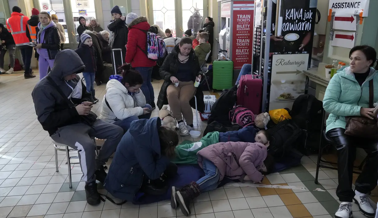 Pengungsi Ukraina berkumpul di stasiun kereta api di Przemysl, Polandia tenggara, pada Rabu (23/3/2022). Polandia telah menerima lebih dari 2 juta pengungsi Ukraina sejak invasi Rusia pada 24 Februari lalu. (AP Photo/Sergei Grits)