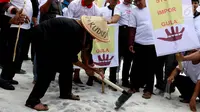 Petani tebu melakukan aksi mencangkul gula rafinasi yang disebar saat unjuk rasa di depan Istana Merdeka, Jakarta, Senin (28/8). Ribaun petani tebu menuntut adanya kebijakan pemerintah terkait produksi gula yang pro petani gula (Liputan6.com/Angga Yuniar)