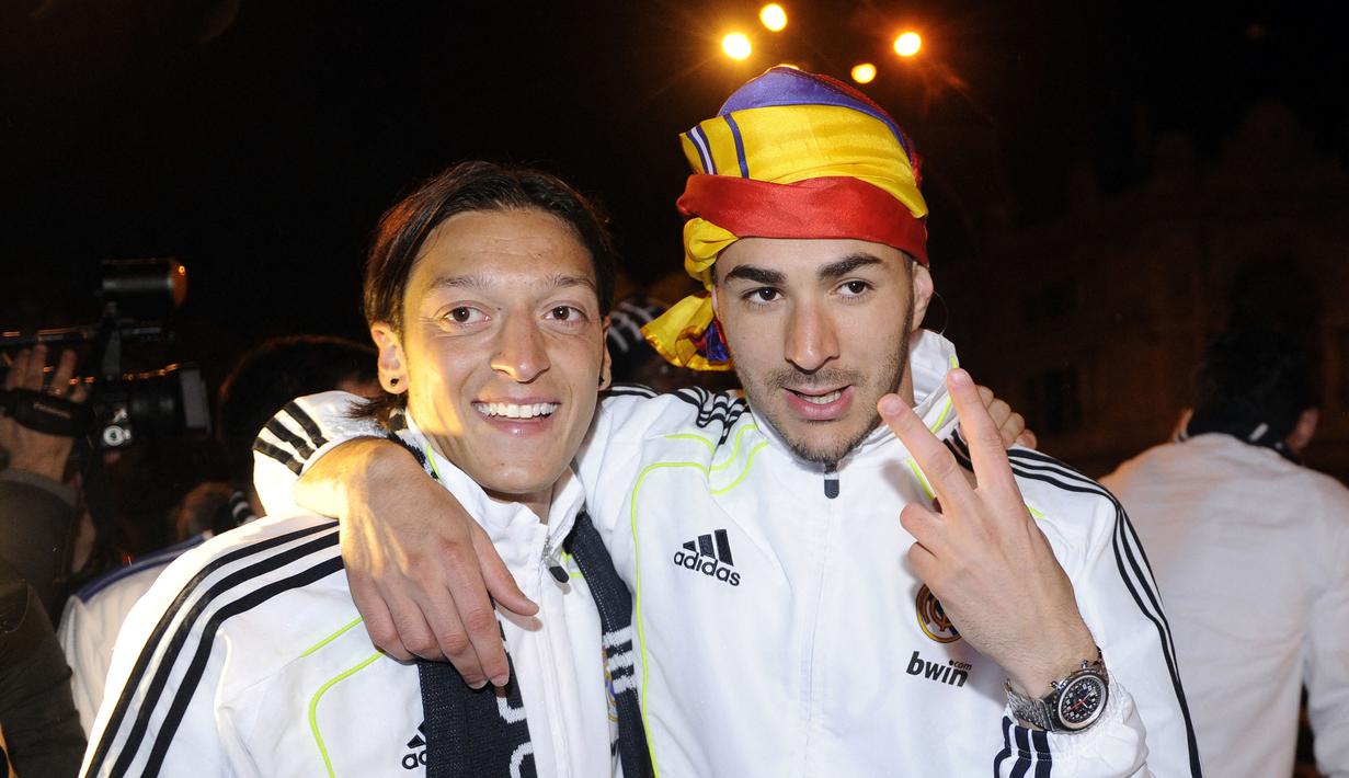 Pemain Real Madrid, Karim Benzema berpose bersama rekannya, Mesut Ozil setelah memenangkan final Piala Spanyol melawan Barcelona di Madrid, 20 April 2011. (AFP/Dominique Faget)