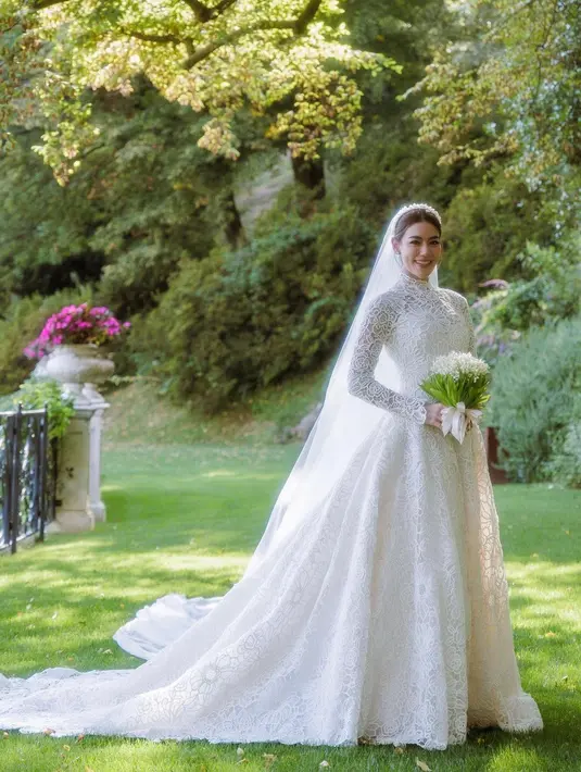 Untuk pemberkatan, Kimberley mengenakan long sleeve wedding gown warna putih gading dengan detail high neck.  [Dok/Dior]