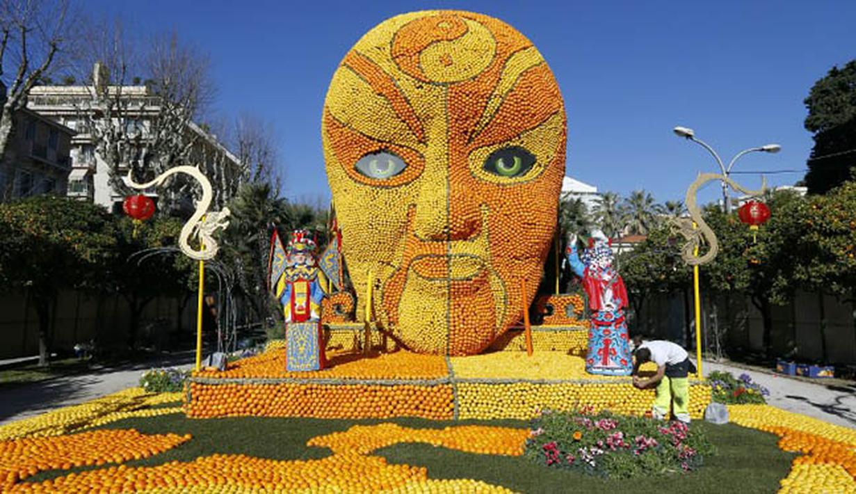 Seorang pria membuat patung yang terbuat dari jeruk dan lemon menjelang festival Lemon di Menton, sebuah kota kecil di Perancis, Rabu (12/2/2015). (AFP PHOTO/Valery Hache)