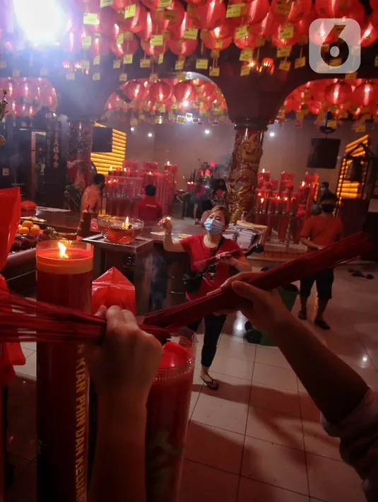 Warga keturunan Tionghoa menyalakan hio untuk sembahyang malam Imlek di Klenteng Boen San Bio Tangerang, Kamis (11/2/2021). Meskipun di tengah pandemi Covid 19, sembahyang Imlek 2572 dilakukan dengan protokol kesehatan yang ketat dan membatasi jumlah warga yang sembahyang (Liputan6.com/Angga Yuniar)