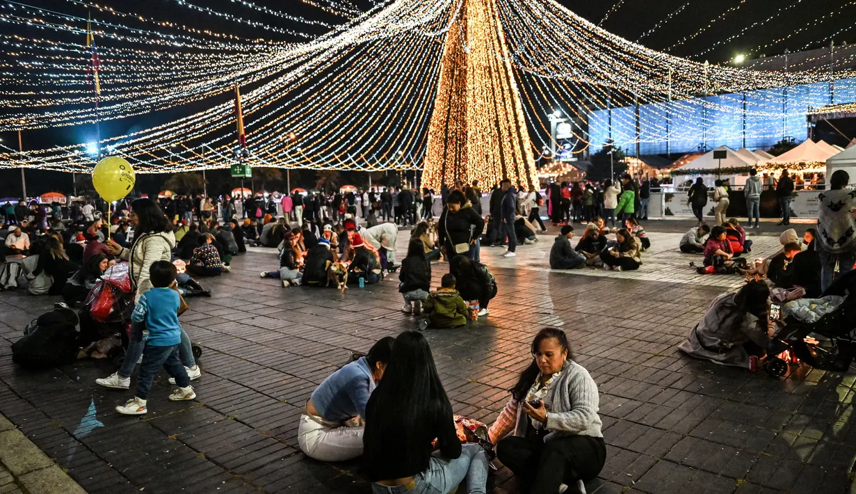 Keluarga-keluarga menyalakan lilin pada Hari Lilin Kecil ('Dia de las velitas'), di Bogota pada tanggal 7 Desember 2023. (Juan BARRETO/AFP)