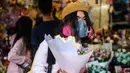 Seorang pria mengenakan masker pelindung sebagai tindakan pencegahan terhadap virus corona COVID-19, membeli bunga untuk menandai Hari Valentine di Hong Kong (14/2/2020). (AFP Photo/Philip Fong)