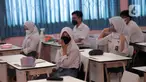 Siswa mengikuti uji coba pembelajaran tatap muka (PTM) terbatas di SMAN 1 Kota Tangerang, Banten, Senin (6/9/2021). Dinas Pendidikan Provinsi Banten uji coba PTM di SMA di Kota Tangerang secara terbatas dengan sistem bergiliran serta menerapkan protokol kesehatan ketat. (Liputan6.com/Angga Yuniar)