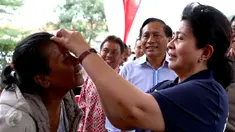 Menkes Nila F Moeloek meneteskan obat mata pada seorang warga saat menghadiri HUT ke 21 Indosiar, Depok, Sabtu (9/1/2016). Indosiar menggelar bakti sosial dan pengobatan gratis dalam memperingati HUT ke 21. (Liputan6.com/Yoppy Renato)