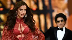 Model asal Rusia, Irina Shayk memakai lingerie merah dipadu luaran bernuansa merah metalik bertekstur rumbai dalam fashion show Victoria's Secret di Paris, Rabu (30/11). Tak disangka jika Irina Shayk tengah hamil anak pertama. (Martin BUREAU/AFP)