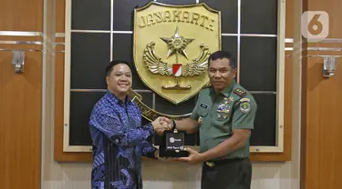 Director Programming SCTV, David Suwarto (kiri) memberikan plakat ke Pangdam Jaya Mayjen TNI Eko Margiyono seusai kunjungan di Makodam Jaya, Jakarta, Selasa (10/12/2019). Kunjungan ini untuk menjalin hubungan kedua pihak. (Liputan6.com/Herman Zakharia)