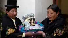 Wanita membawa tengkorak manusia yang dihias usai berdoa di kapel Pemakaman Umum selama Festival Natitas di La Paz, Bolivia (8/11). Ritual ini digelar setiap tahunnya di Bolivia. (AP Photo/Juan Karita)