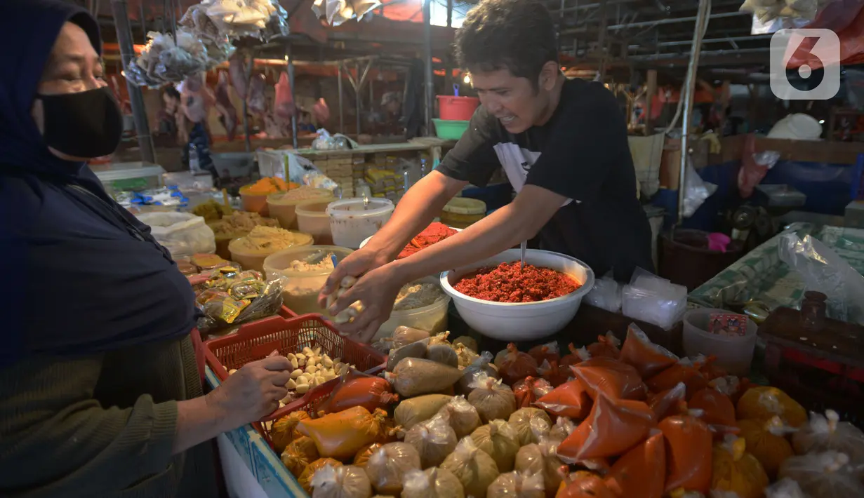Pedagang  melayani pembeli di pasar tradisoonal Kebayoran, Jakarta, Rabu (3/11/2021). Meskipun pemerintah sudah menurunkan level 1 masa PPKM berskala mikro pedagang mengatakan masih resah karena menurunnya pendapatan harian ditambah sejumlah bahan pokok mengalami kenaikan. (merdeka.com/Imam Buhori)