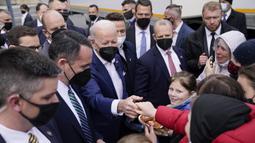 Presiden Amerika Serikat Joe Biden menyalami seorang wanita saat bertemu dengan pengungsi Ukraina dan pekerja bantuan kemanusiaan pada kunjungan ke PGE Narodowy Stadium di Warsawa, Polandia, 26 Maret 2022. (AP Photo/Evan Vucci)