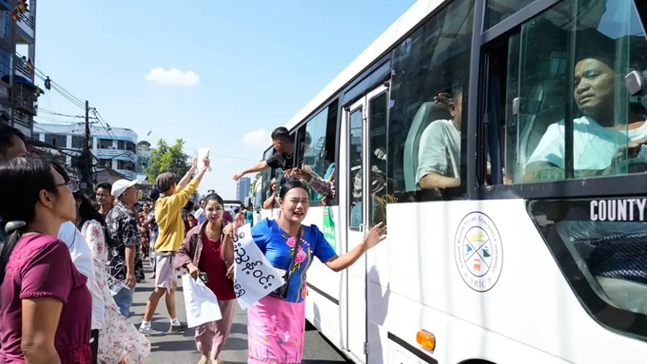Para tahanan yang dibebaskan, berada di dalam bus, disambut oleh anggota keluarga dan rekan-rekan mereka setelah meninggalkan Penjara Insein pada Minggu (4/1/2026), di Yangon, Myanmar.