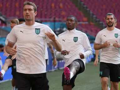 Bek timnas Austria, David Alaba (tengah) melakukan pemanasan selama pelatihan tim di Johan Cruyff Arena di Amsterdam, Rabu (16/6/2021). Belanda akan berhadapan dengan Austria di matchday ke-2 Grup C Euro 2020 pada Jumat (18/6/2021) dinihari. (AP Photo/Peter Dejong)