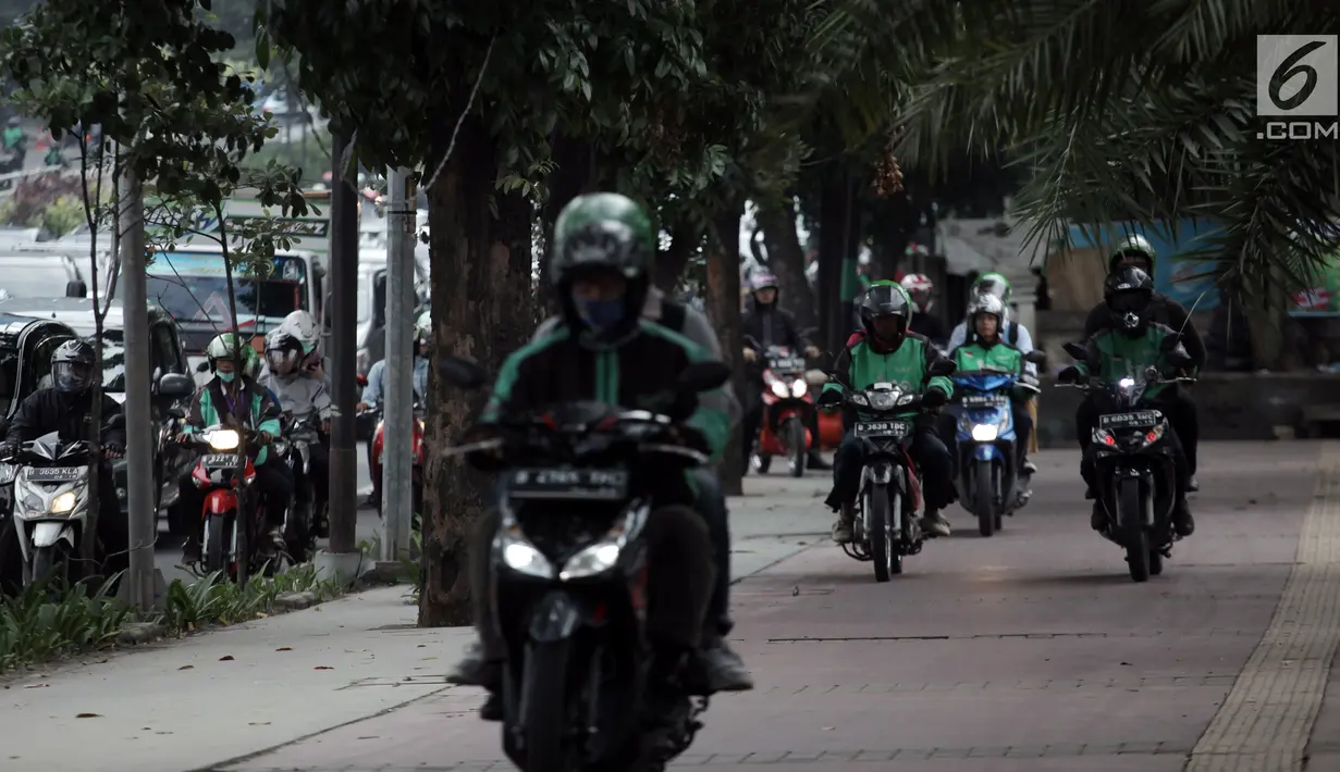 Sejumlah pengendara ojek online nekat menaiki jalur trotoar untuk menghindari kemacetan di Jalan Casablanca, Jakarta, Senin (8/1). Aksi pengendara sepeda motor tersebut menutup jalur bagi para pejalan kaki. (Liputan6.com/Arya Manggala Nuswantoro)
