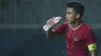 Bek Timnas Indonesia, Nurhidayat Haris, melepas dahaga saat melawan Thailand pada laga PSSI 88th U-19 di Stadion Pakansari, Jawa Barat, Minggu (23/9/2018). Kedua negara bermain imbang 2-2. (Bola.com/Vitalis Yogi Trisna)