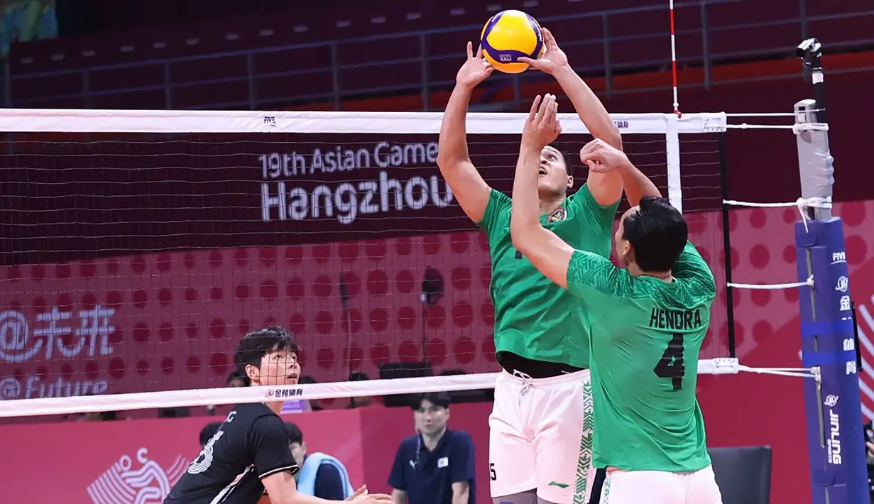 Pemain Timnas bola voli putra Indonesia, Dio Zulfikri (tengah) memberi umpan kepada rekannya, Hendra Kurniawan saat menghadapi Korea Selatan pada laga perebutan peringkat 7-8 Asian Games 2022 di LSC Gymnasium, Hangzhou, China, Selasa (26/9/2023) siang WIB. (AVCVolley)