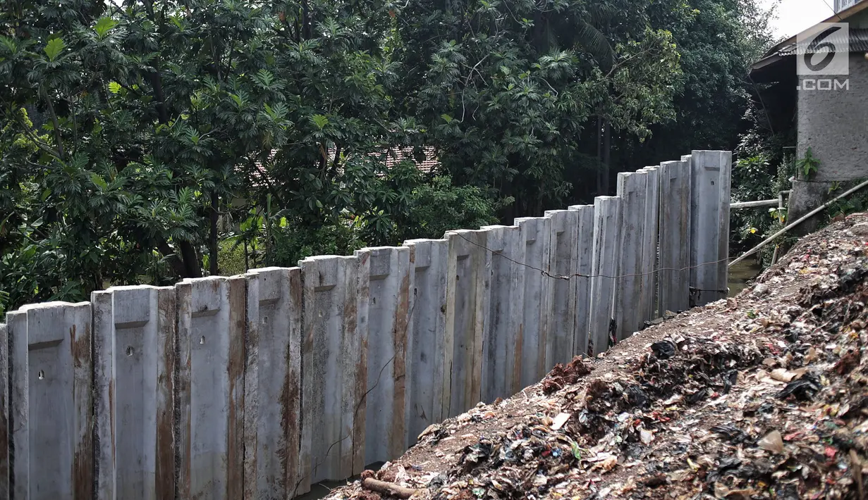 Tiang pancang turap aliran anak kali ciliwung yang terbengkalai di kawasan Jalan Gudang Air, Jakarta, Selasa (12/2).Pengerjaan yang tak kunjung selesai menyebabkan jalan hadidji dan sekitar kerap banjir jika hujan deras.(Liputan6.com/Faizal Fanani)