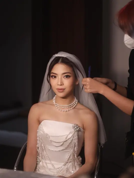 Cantiknya Clarissa dibalut gaun pengantin tanpa tali berwarna putih dengan detail mutiara yang serasi dengan kalung bertumpuk yang dikenakannya. Penampilannya semakin menarik dengan veil yang dikenakannya. [Foto: Instagram/clarissatanoe]