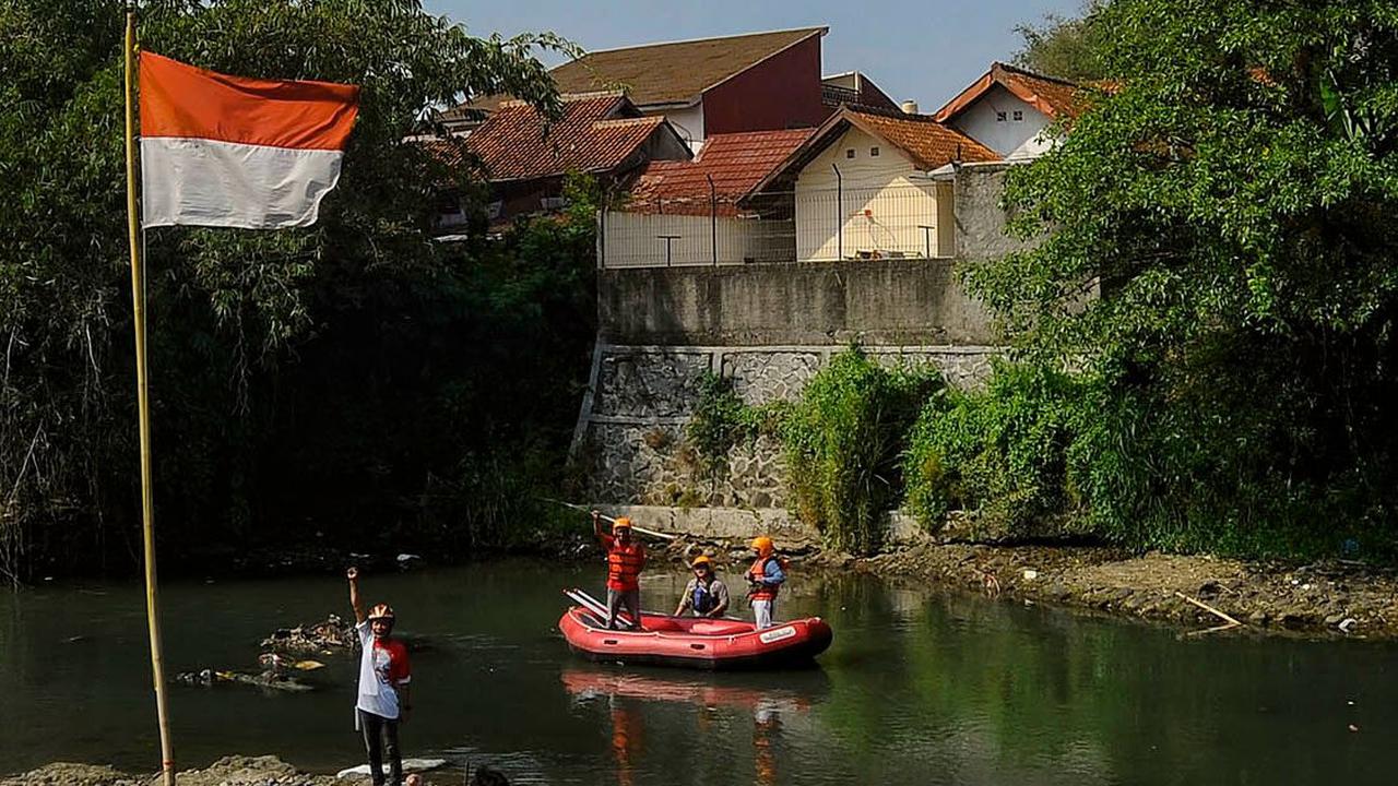 Warga di sana melaksanakan upacara bendera di tengah Sungai Ciliwung yang hampir kering akibat musim kemarau yang masih melanda sampai sekarang.