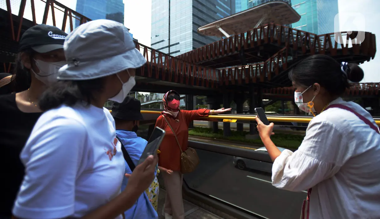 <p>Warga berfoto saat naik bus tingkat Transjakarta dengan atap terbuka di Jakarta, Selasa (10/5/2022). Bus wisata tersebut beroperasi pukul 10.00-21.00 WIB dengan rute Jakarta Modern (BW2) rute Juanda-Istiqlal (PP) dan Pencakar Langit (BW4) rute Irti-Monas (PP) hingga 11 mei 2022. (merdeka.com/Imam Buhori)</p>