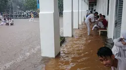 Banjir yang disebabkan hujan berkepanjangan di ibukota itu membuat sejumlah sekolah memulangkan anak didiknya lebih awal, Jakarta, Senin (9/2/2015). (Antara Foto/Fanny Octavianus)