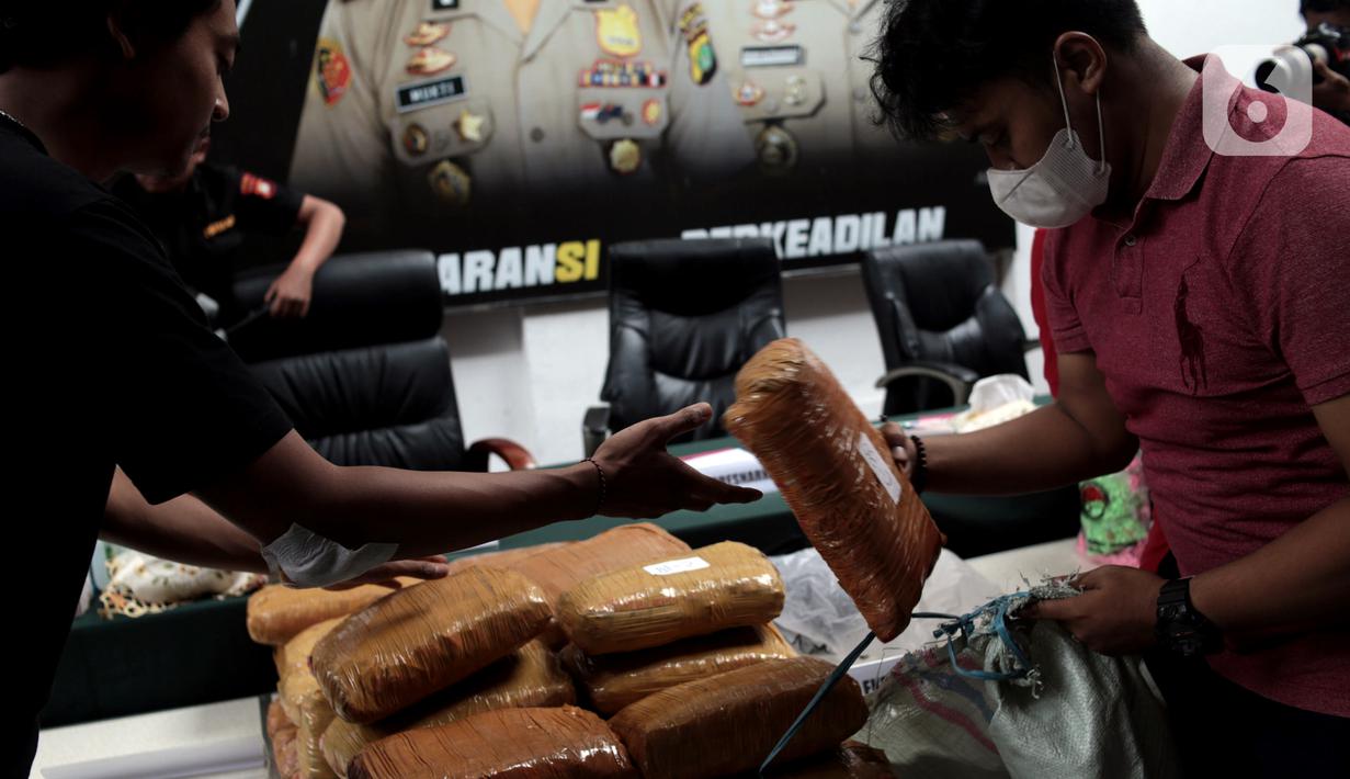 Petugas kepolisian menghadirkan barang bukti narkoba saat rilis hasil Operasi Kewilayahan Nila Jaya 2022 di Mapolda Metro Jaya, Jakarta, Selasa (13/12/2022). Direktorat Reserse Narkoba Polda Metro Jaya bersama Satuan Reserse Narkoba Polres berhasil mengamankan 278 tersangka dari 222 kasus serta barang bukti berupa 13,7 Kg sabu, 147,22 Kg ganja, 2.088 butir ekstasi, 229.759 butir obat baya, 119 gram tembakau sintetis, dan 1,17 liter cairan narkotika dalam Operasi Nila Jaya 2022 yang berlangsung 16-30 November 2022. (merdeka.com/Iqbal S. Nugroho)
