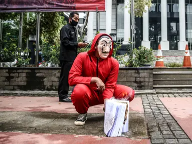 Seorang mahasiswa dari Mahasiswa Independen secara simbolis membakar salinan naskah UU Cipta Kerja di depan Gedung MK, Jakarta, Selasa (27/10/2020). Mahasiswa menyatakan aksi tersebut bentuk ketidakpercayaan kepada MK bila proses uji materi UU Cipta Kerja dilakukan. (Liputan6.com/Faizal Fanani)