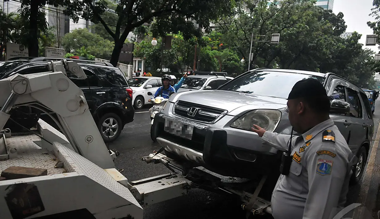 Dinas Perhubungan DKI Jakarta membawa mobil yang terkena razia karena parkir sembarang di depan DPRD, Jakarta, Senin (12/1/2015). (Liputan6.com/Johan Tallo)