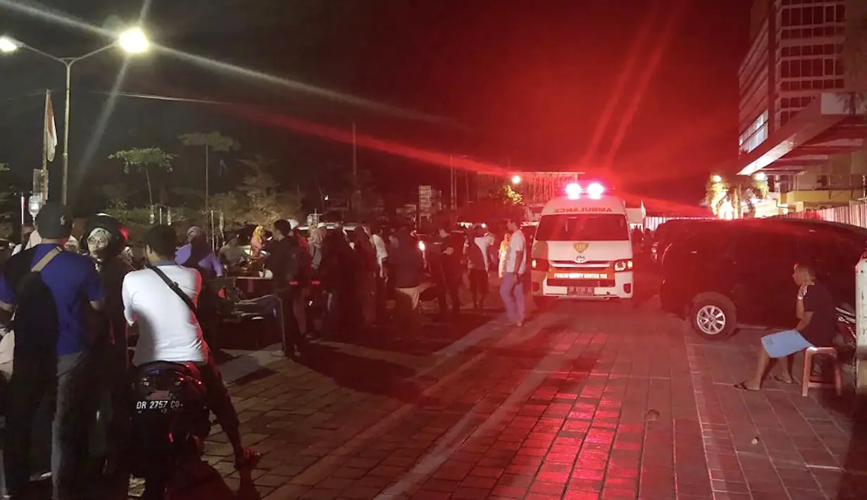 Mobil ambulans bergegas keluar rumah sakit saat gempa mengguncang Lombok Utara, NTB Minggu malam (5/8). BMKG menyatakan gempa memiliki kedalaman 15 km, terletak di 8.25 Lintang Selatan ,116.49 Bujur Timur Laut.  (AFP Photo/Rita Siswati)