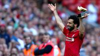 Mohamed Salah mengangkat penghargaan Sepatu Emas yang diraihnya setelah Liverpool menekuk Brighton and Hove Albion di Anfield, Minggu (13/5). Salah menyumbangkan 32 gol, unggul dua gol dari bomber Tottenham Hotspur, Harry Kane. (Dave Thompson/PA via AP)