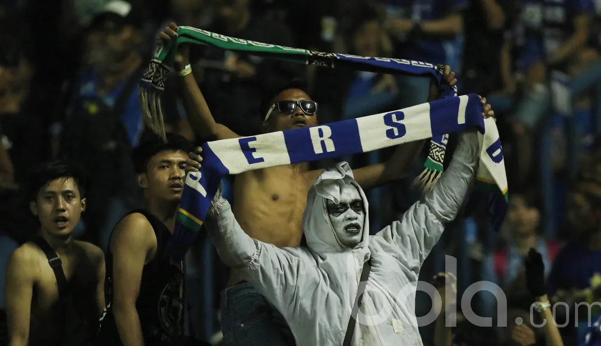 Bobotoh Persib memakai pakaian unik saat mendukung Persib Bandung. Para bobotoh selalu setia mendukung langsung Persib Bandung kala bermain di kandang maupun diluar kandang. (Bola.com/M Iqbal Ichsan)