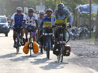 Pemudik bersepeda melintas di Jalan Raya Pantura, Cirebon, Jawa Barat, Sabtu (1/6/2019). Anggota komunitas GWCC asal Tangerang ini melakukan mudik tujuan Yogyakarta dan Pacitan dengan menempuh jarak sekitar 800 Km. (Liputan6.com/Herman Zakharia)