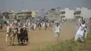 Para penonton menyaksikan dan bersorak-sorai saat para petani berlomba dengan sapi jantan mereka dalam kompetisi balapan sapi tradisional di pinggiran Islamabad, Pakistan, Minggu (27/6/2021). Ditengah pandemi covid-19, balapan sapi ini disaksikan banyak penonton. (Farooq NAEEM/AFP)